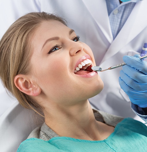Woman receiving dental checkup and teeth cleaning