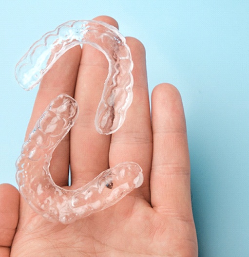 Patient holding clear aligners in Goodyear