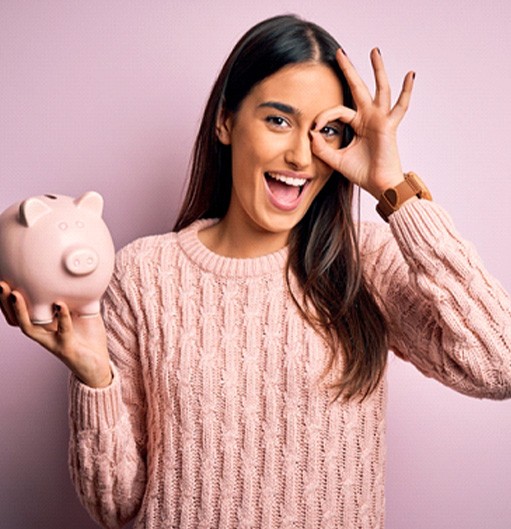 Woman with beautiful smile, holding piggy bank