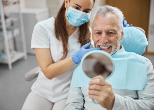 Dentist pointing to dental implant model