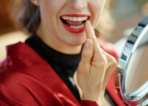 dentist holding veneers up to a patient’s smile