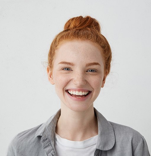 closeup of woman smiling against gray background  
