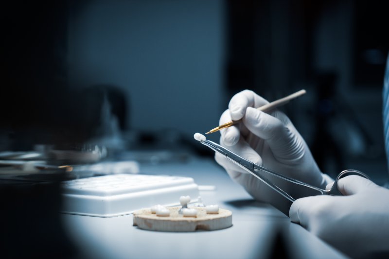 A lab worker processing a dental crown