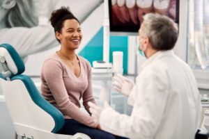 Young woman learning more about dentures from her dentist